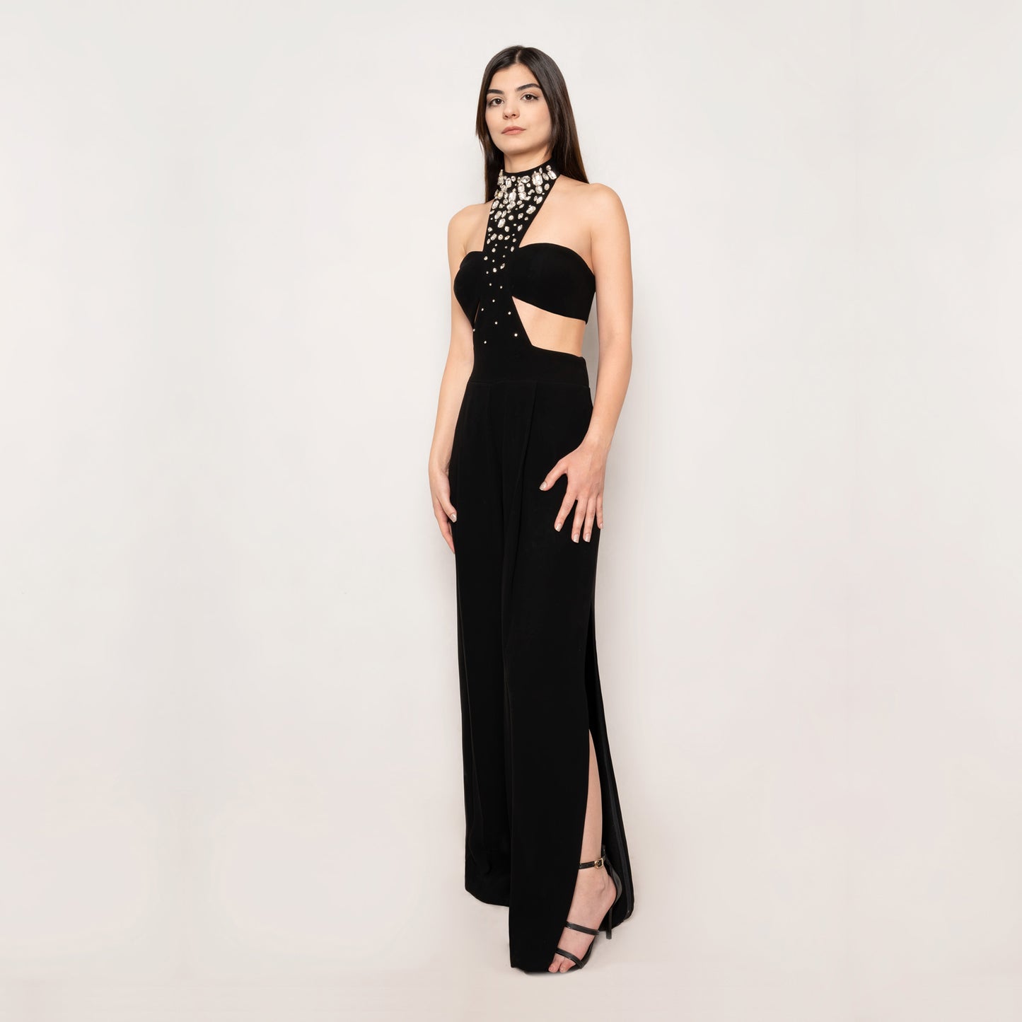 Side view of the Crystal Jumpsuit by Tehran, highlighting the sophisticated side slit and ruched detailing. The concealed side zip ensures a seamless fit for a chic and stylish silhouette.