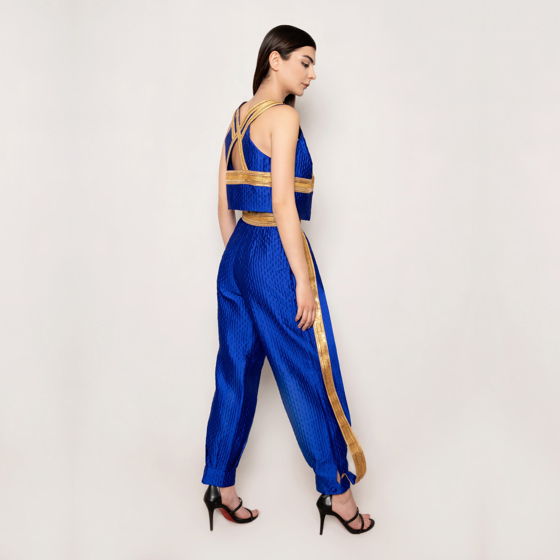 Side view of the Golden Nomad Set in Klein Blue by Tehran, emphasizing the elegant vest's clean lines and intricate trims. The tapered pants with elasticated ankles create a refined yet comfortable silhouette.