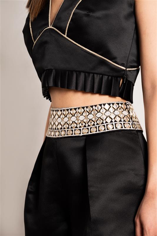 Close-up view of the "Top & Shorts Set" by Tehran Official in black silk, highlighting intricate pleated detailing, contrasting trims, and the luxurious quality of 100% silk fabric. The craftsmanship emphasizes refined tailoring and elegant draping, showcasing the meticulous attention to design elements and premium materials.